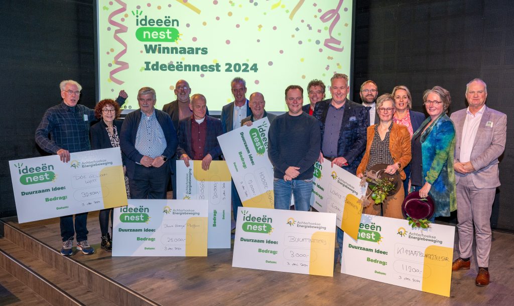 Alle deelnemers met de cheque die ze hebben ontvangen op het podium