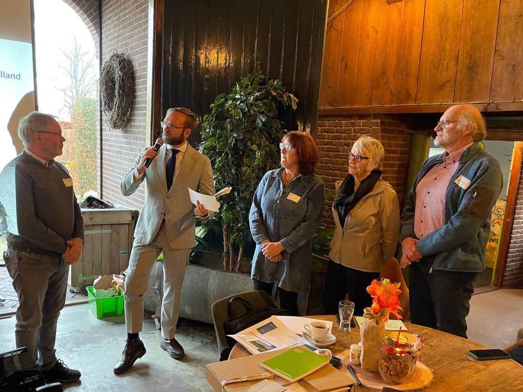 Wethouder Gerjan Teselink reikt de tafelzetters uit aan de vrijwilligers van VVV Ruurlo, VVV Neede, Toeristische Informatie Borculo en Toeristisch Informatiepunt Eibergen.