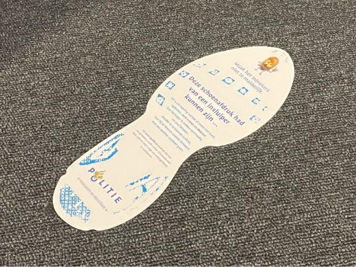 witte schoenafdruk van papier met daarop de waarschuwing over inbraak.