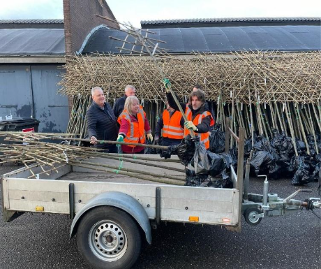 Wethouder van der Noordt staat met vrijwilligers achter een aanhanger met daarin bomen die worden uitgedeeld vanuit de actie 'Elke Berkellander een Boom'