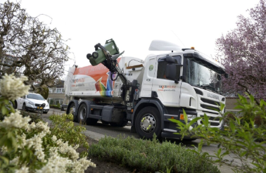 een wagen van Twente Milieu die bezig is met het ophalen van afval